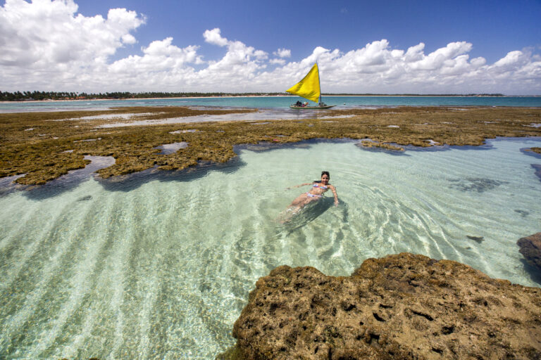 Woman swimming and relaxing on natural pool in Porto de Galinhas